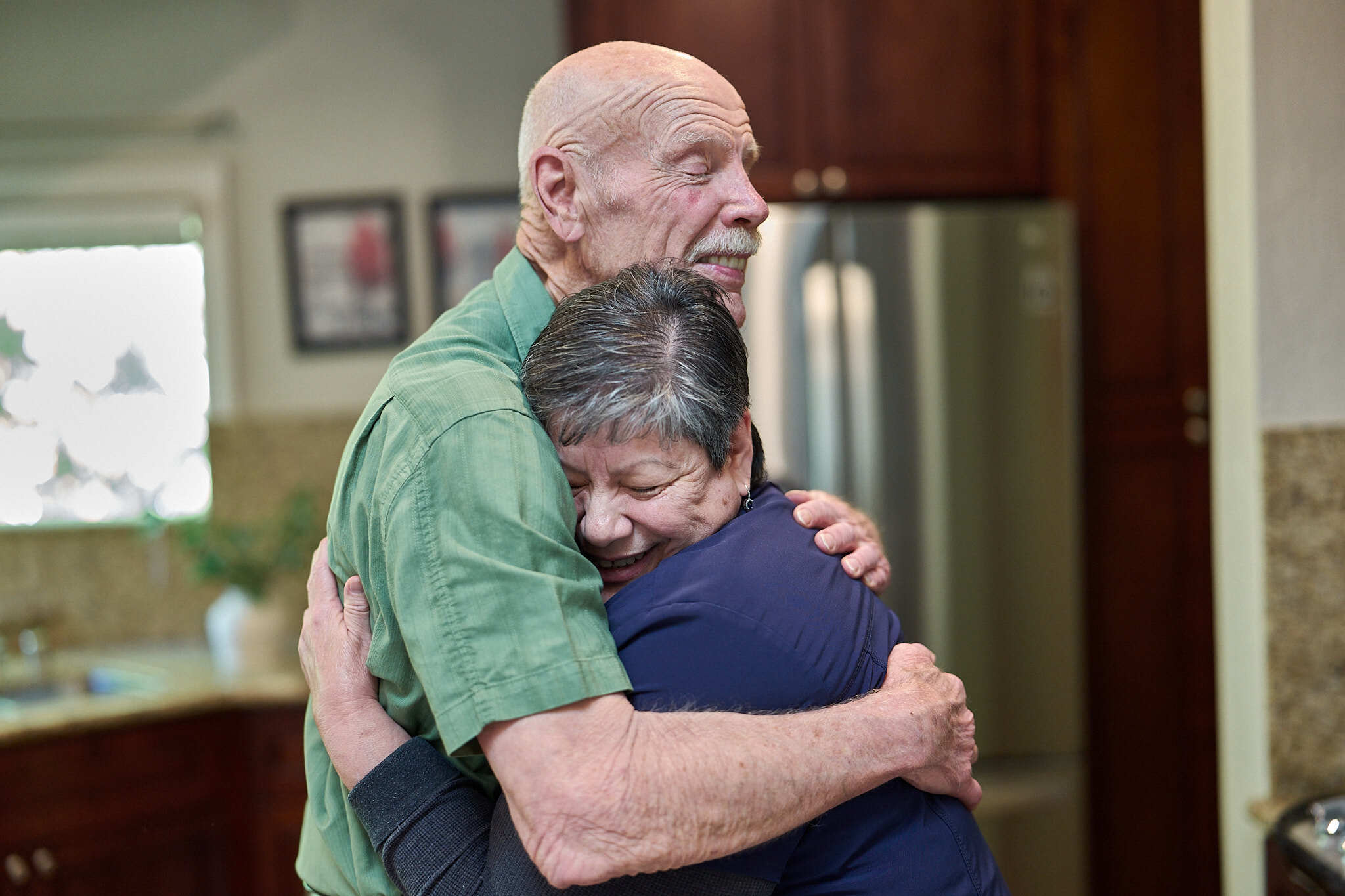 Elderly patient hugging a caregiver.