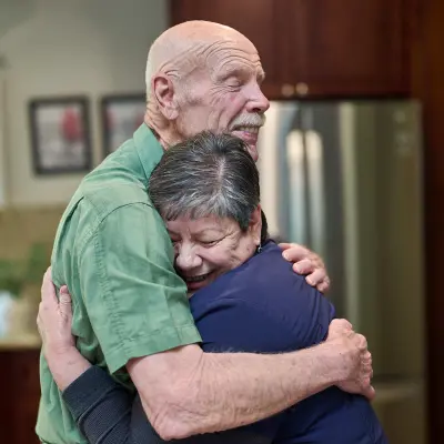 Elderly patient hugging a caregiver.